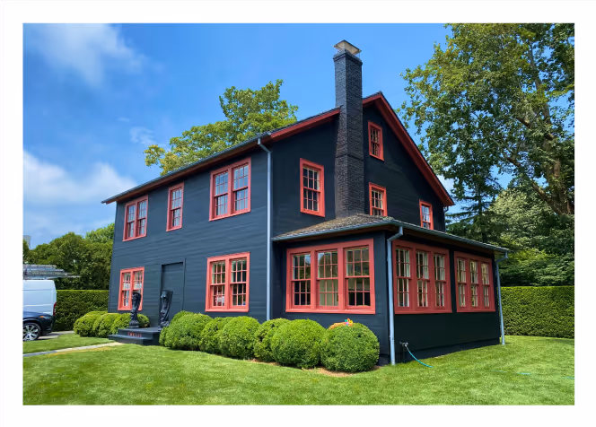 Freshly painted dark blue and red two-story house in Long Island after complete exterior restoration by Palencia’s Painting & Window Cleaning