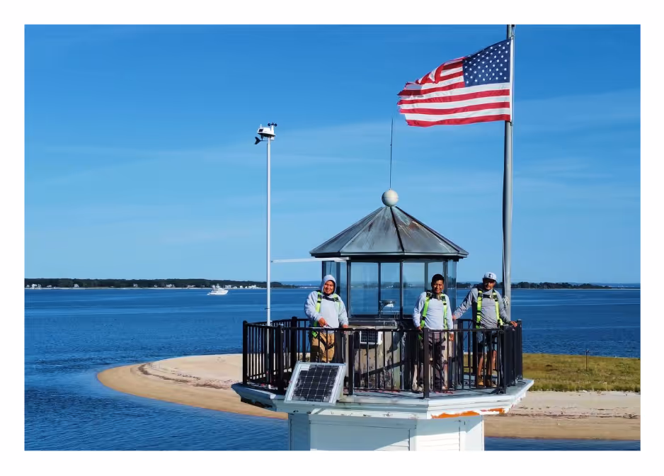 Palencia’s Painting & Window Cleaning team standing on the restored Bug Lighthouse, representing expert craftsmanship and dedication